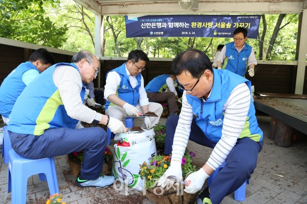 신한은행 임원 및 본부장들이 지난 24일 서울 성동구 서울숲에서 설치된 꽃 화분을 교체하는 봉사활동을 하고 있다. 사진=신한은행
