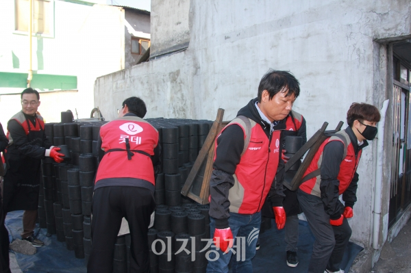 롯데건설 샤롯데봉사단이 15일 부산 매축지마을에서 연탄 배달을 돕고 있다. 사진=롯데건설