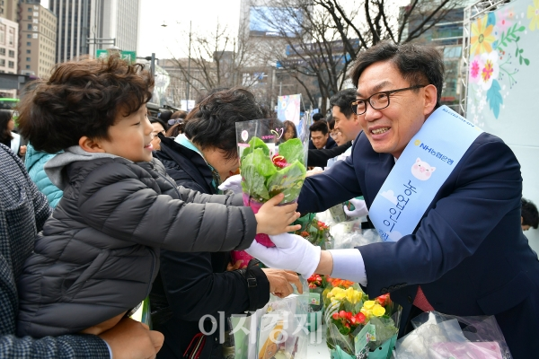 이대훈(오른쪽) NH농협은행장이 지난 14일 서울 종로구 광화문 일대에서 '새봄맞이 고객사랑 가두캠페인'에 참가해 어린이 고객에게 화분을 나눠주고 있다. 사진=NH농협은행