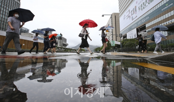 우산을 쓴 시민들이 7월13일 서울 광화문에서 출근길 발걸음을 재촉하고 있다. 사진=고성준 기자
