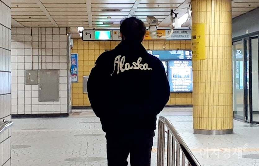 한 20대 청년이 등에 ‘Alaska’라고 적힌 겨울 옷을 입고 지하철역으로 들어가고 있다. 이날 낮 최고 기온은 20℃였다. 사진=문룡식 기자.