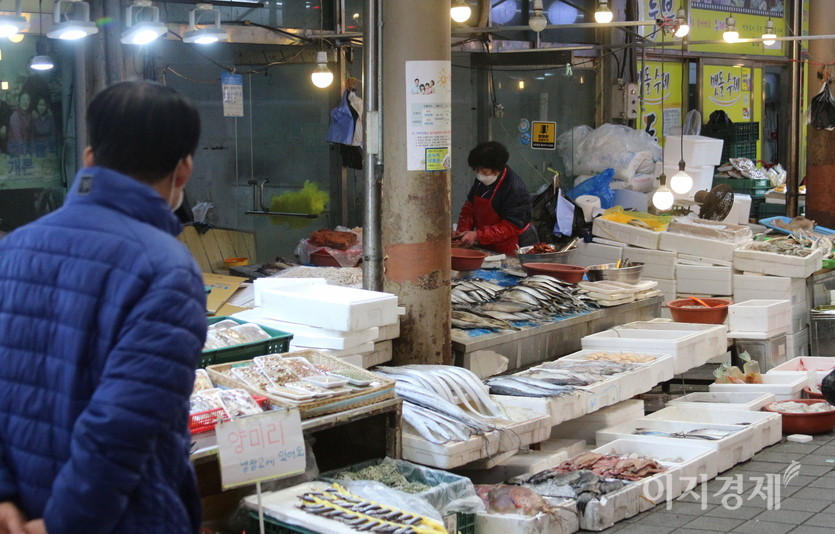 현대시장 어물전. 고객이 없다. 어물전을 지나가는 한 남성이 생선 가격을 힐끔 쳐다보고 지나가고 있다. 사진=정수남 기자