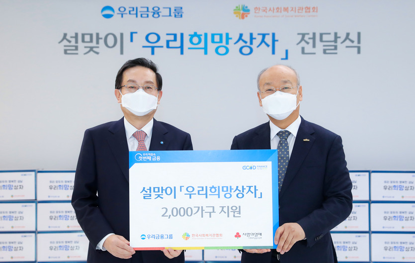 (왼쪽부터)손태승 회장이 남국희 한국사회복지관협회장에게 ‘우리희망상자’ 2000개를 전달하고, 기념사진을 찍고 있다. 사진=우리금융