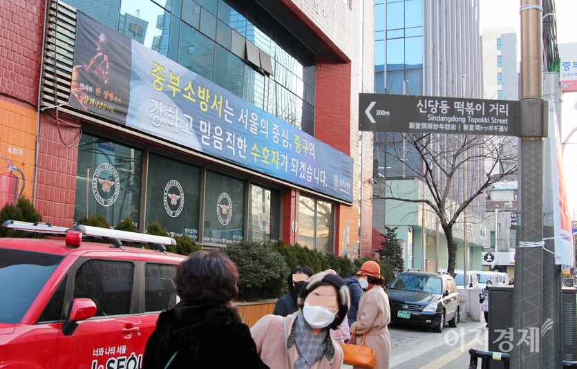중년으로 보이는 여성 네명이 서울 중부소방서에서 100여미터 떨어진 신당동 떡볶이 거리를 찾고 있다. 머리 위에 이정표가 보인다. 사진=정윤서 기자.