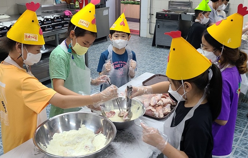 [사진 2] BBQ치킨_치킨대학 치킨캠프에 참여한 아이들이 황금올리브 치킨을 만들기위해 반죽을 묻히고 있다.jpg