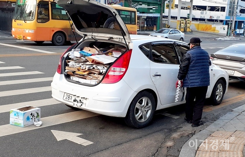 경기도 성남시 중원구에 있는 신구대학교 사거리에서 한 노인이 현대차 소형 i30에 폐지를 실고 있다. 사진=정수남 기자