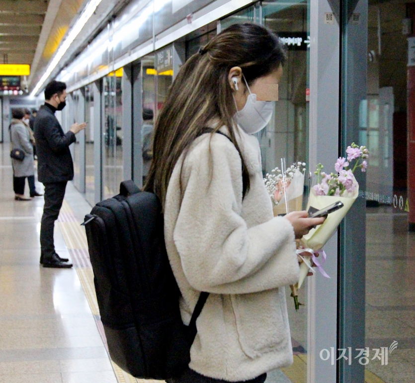 20대로 보이는 봄처녀가 꽃다발을 들고 열차를 기다리고 있다. 누구에게 가는 걸까? 사진=김진이 기자