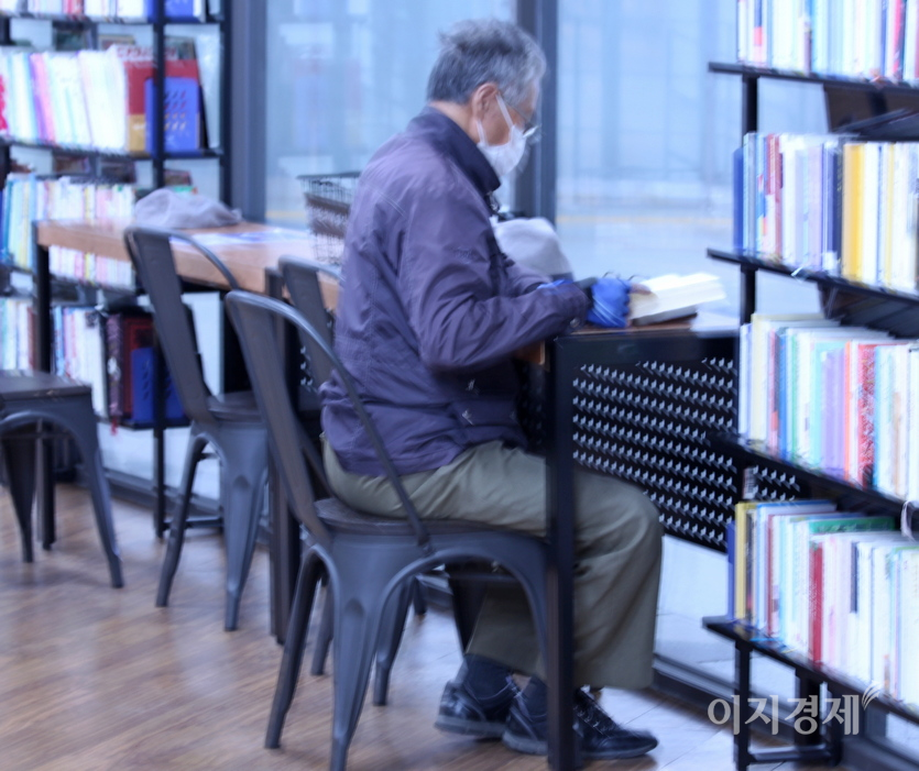 역사에 있는 한 중고서점 안. 코로나19 대확산으로 운영하지 않던 독서대가 다시 열렸다. 한 노인이 책을 읽고 있다. 사진=정수남 기자