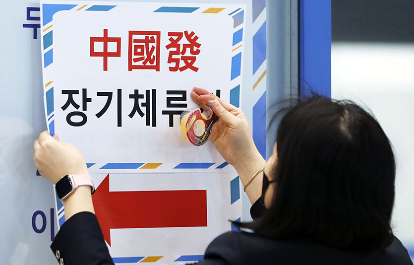 9일 인천국제공항에서 공항 관계자가 중국발 장기체류자 입국장 안내문을 붙이고 있는 모습. 사진=뉴시스