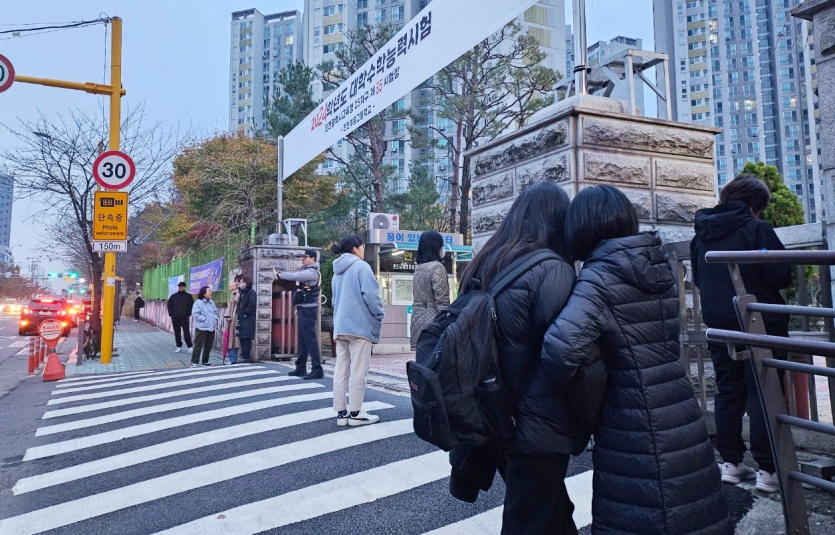 부흥고등학교 앞, 한 학부모와 수험생 자녀가 응원의 말을 나누고 있다. 사진=최준 기자
